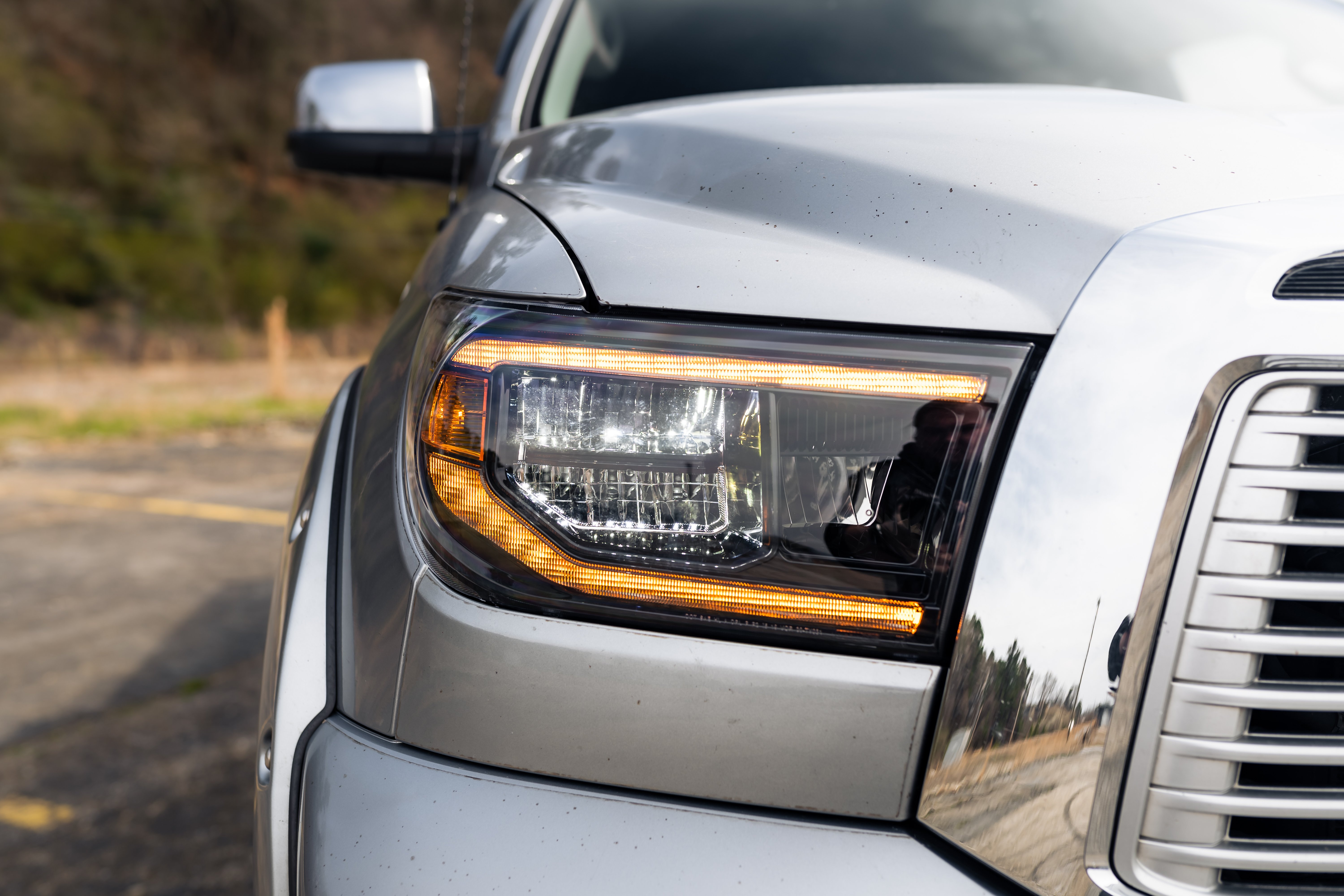 front left close-up view of reflector headlights on a white car