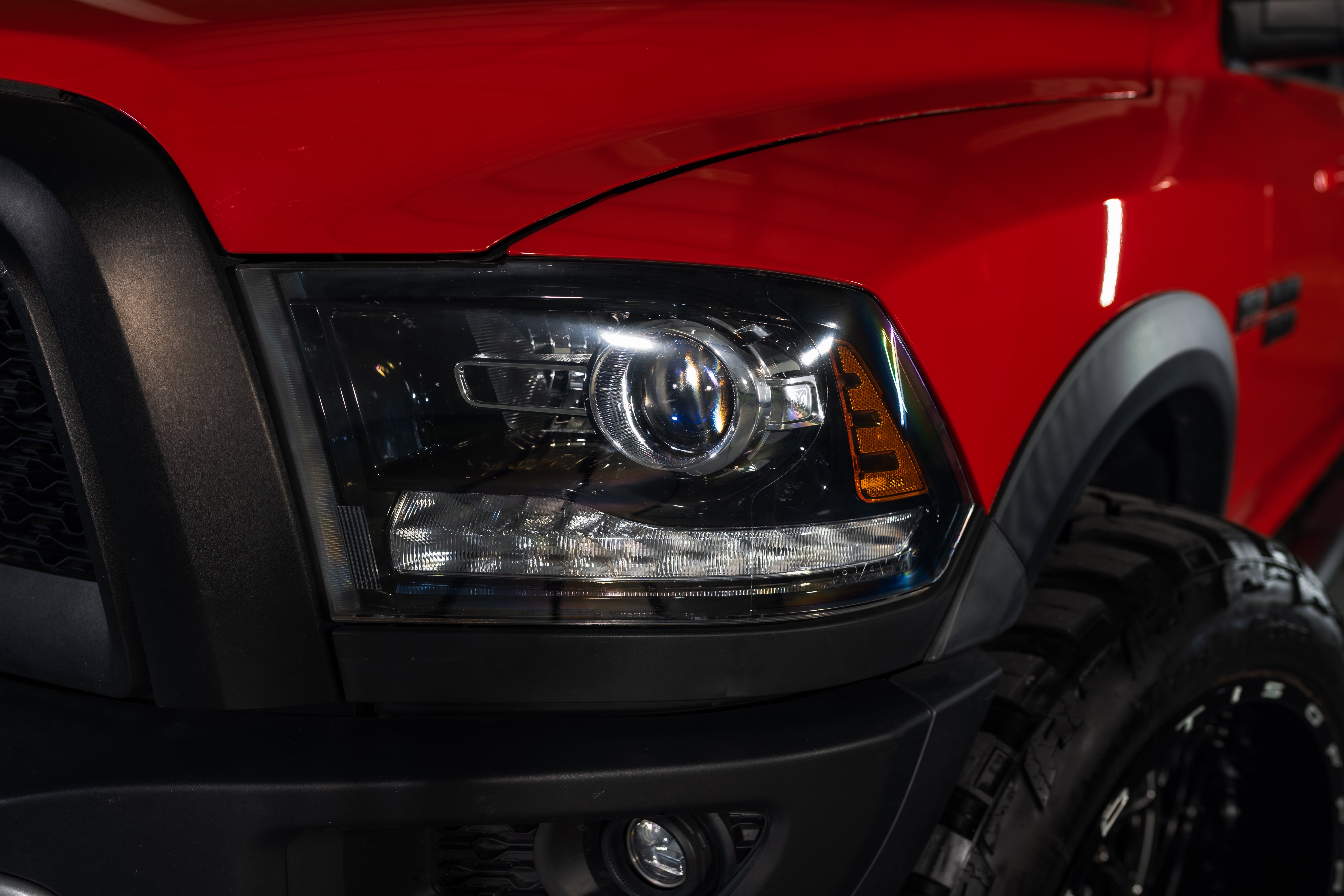 front right close-up view of projector headlights on a red car